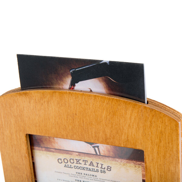 A Menu Solutions country oak wood framed table tent holding a menu on a table.