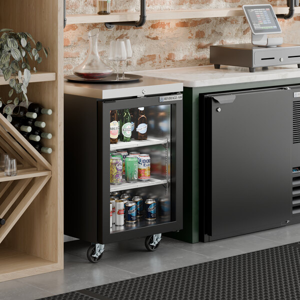 A black counter height glass door back bar refrigerator filled with assorted beverages.