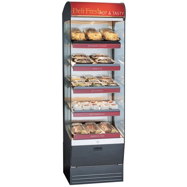 An Alto-Shaam heated display case on a counter in a bakery filled with trays of food.