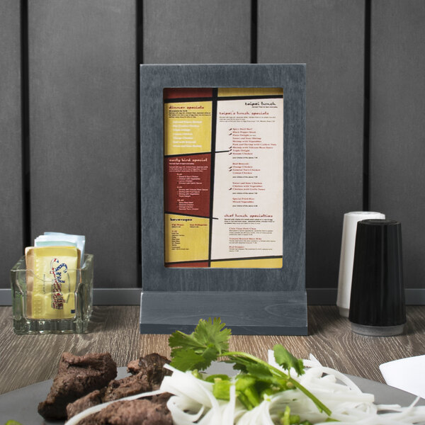 A Menu Solutions wood menu tent on a wood table.