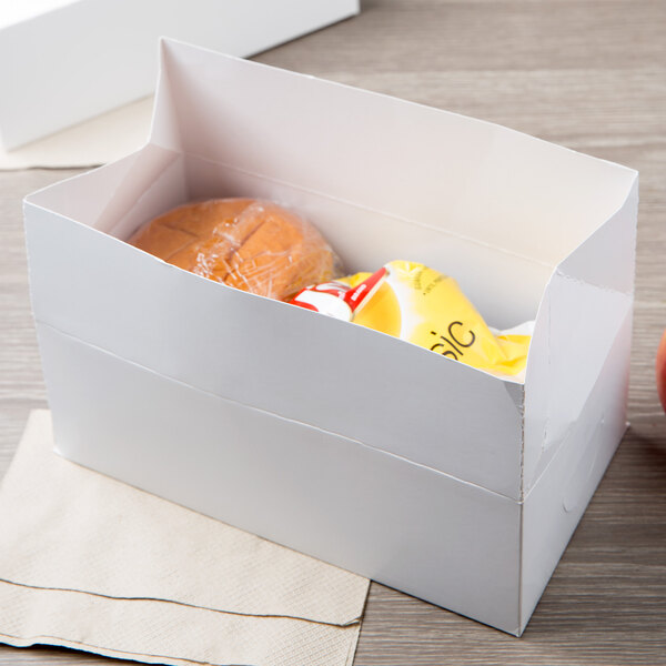 A white Take Out Lunch box with food inside.