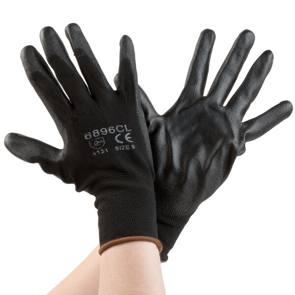 A pair of hands wearing Cordova black gloves with black palms.