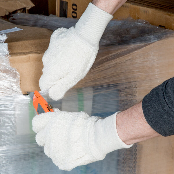 A person wearing Cordova loop-out terry work gloves holding a knife.