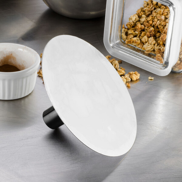 A black Matfer Bourgeat stainless steel mold pack down tool with a white spot on the handle.