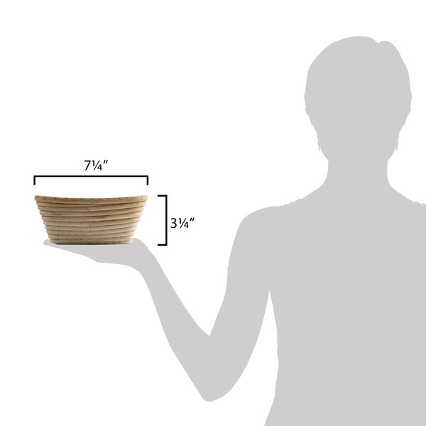 A person holding a Matfer Bourgeat triangle proofing basket.