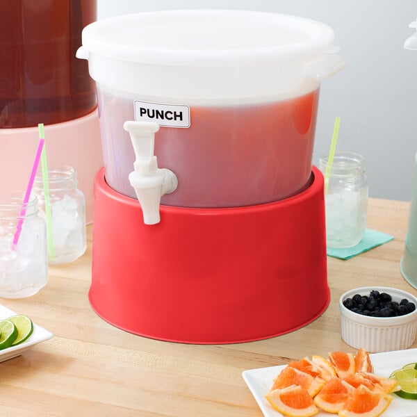 A red Choice beverage dispenser base on a table with drinks and fruit.