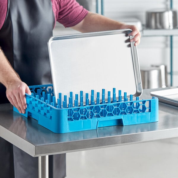 A man holding a Carlisle open end peg tray with blue dishes.