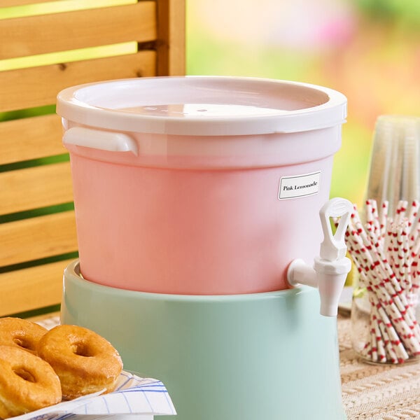 A three-gallon white round beverage dispenser with a spigot, labeled for pink lemonade.