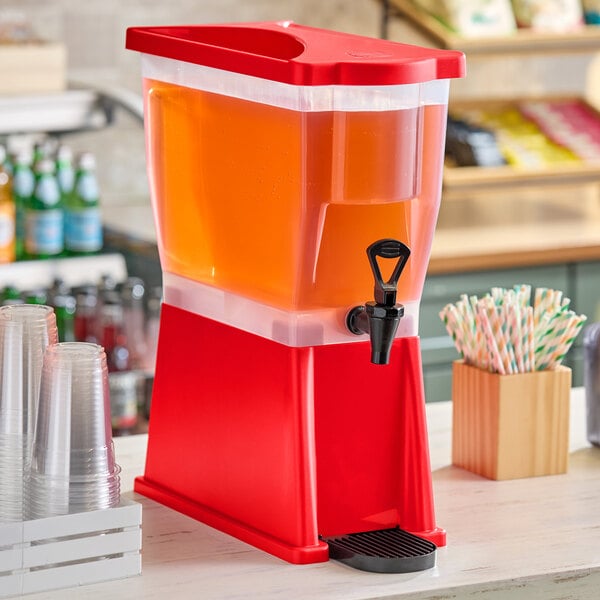 A red slim beverage dispenser filled with juice, featuring a spigot for easy pouring.