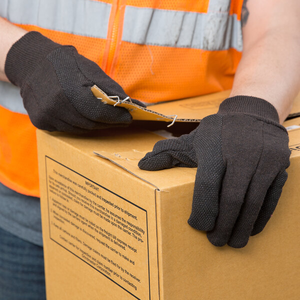 A person wearing Cordova jersey gloves and holding a box.