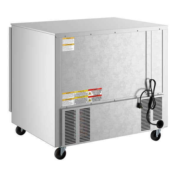 A low profile, stainless steel undercounter refrigerator on casters with a power cord and ventilation grilles.