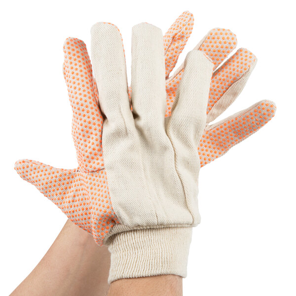 A hand wearing a pair of Cordova work gloves with orange PVC dots.