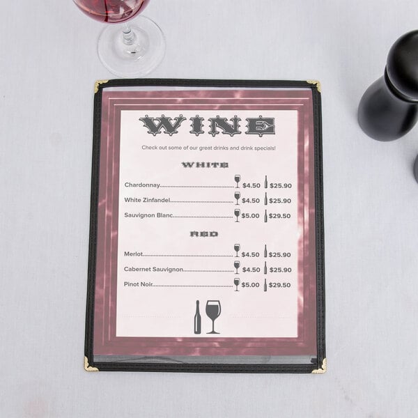 A burgundy menu with a marble border on a table with a glass of wine.