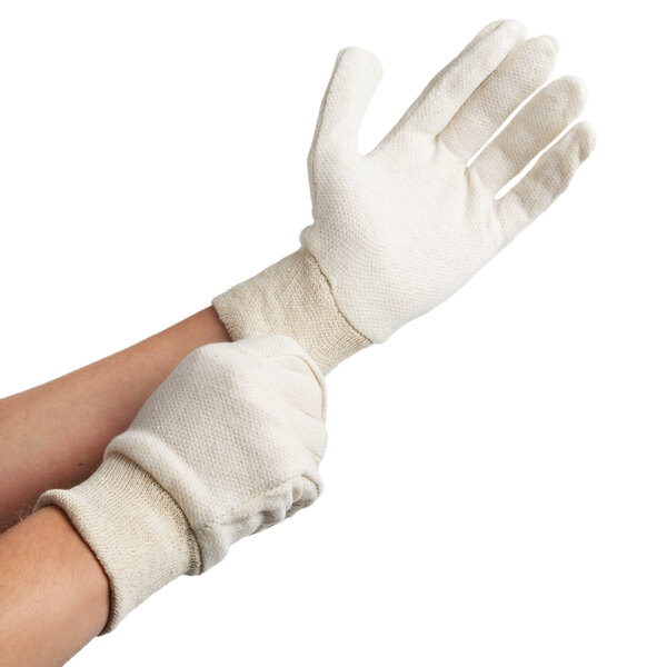 A pair of hands wearing white Cordova jersey gloves.