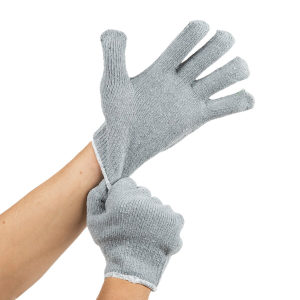 A person putting on gray Cordova loop-in jersey gloves.