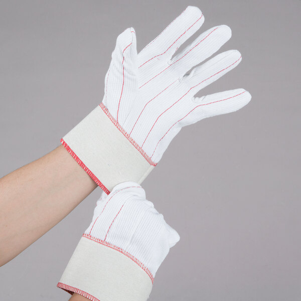 A pair of white Cordova work gloves with red stitching.