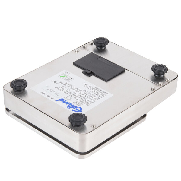 An Edlund Resolution RGS-600 portion scale, a metal box with black knobs and a black rectangular object inside.