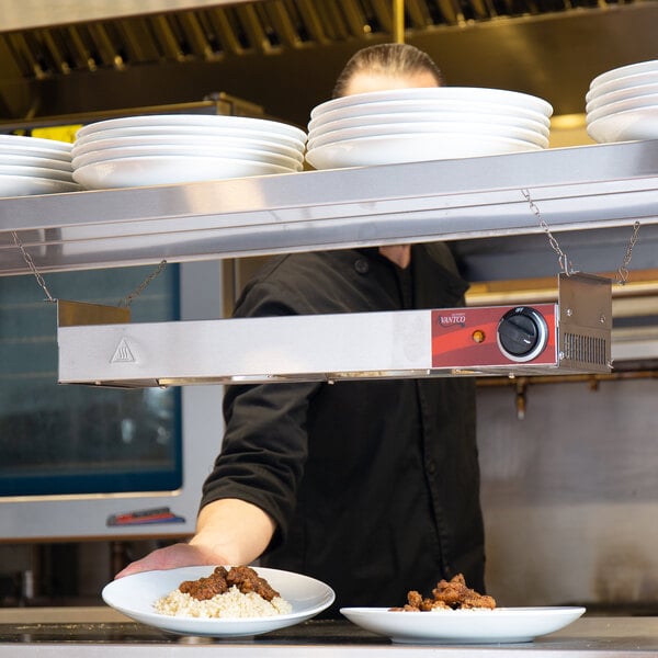 silver hanging heat lamp over plates of food