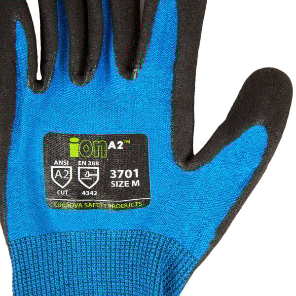 A close up of an extra-large Cordova Sapphire Blue warehouse glove with black sandy nitrile palm coating.