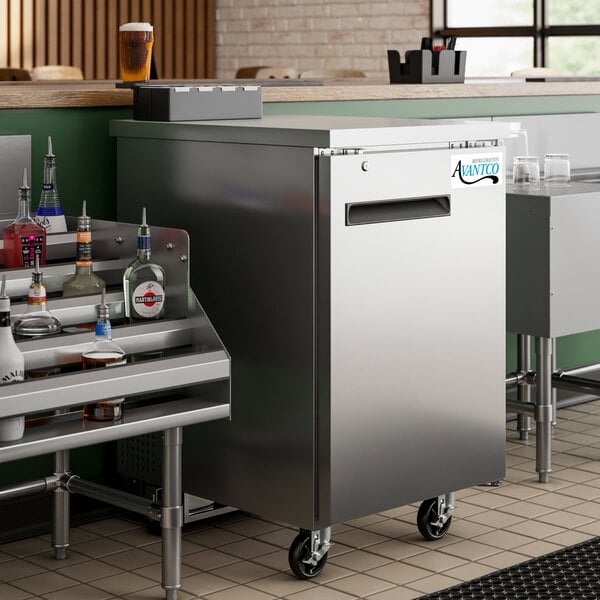 An Avantco stainless steel back bar refrigerator with a shelf and bottles of liquor.