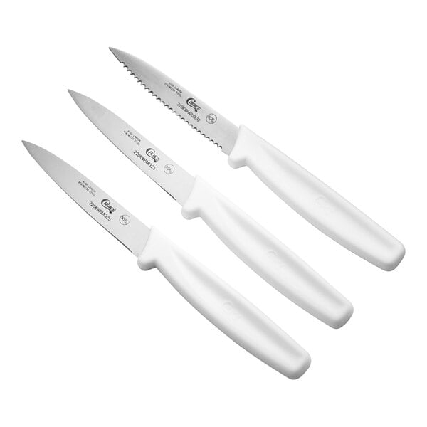 A set of three paring knives with white handles, including one serrated and two smooth edge blades.