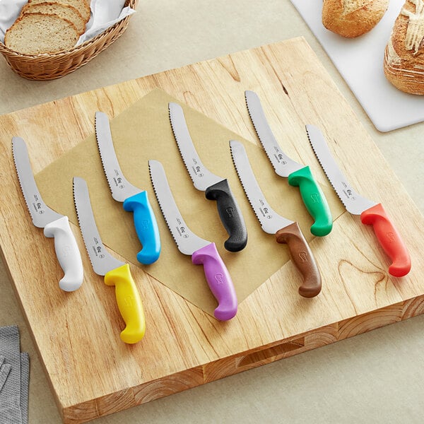 A Choice bread knife with white handles and serrated edge on a cutting board.