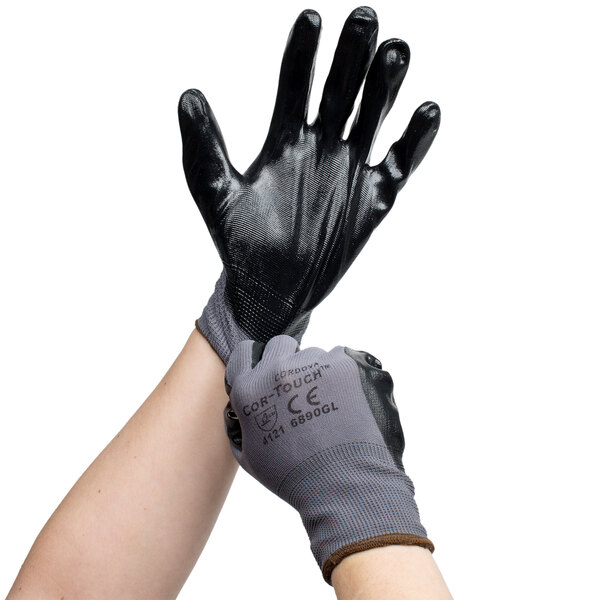 A pair of hands wearing Cordova black gloves with black nitrile palms.