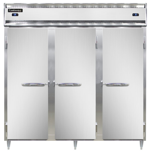 Three white Continental refrigerators with open doors.