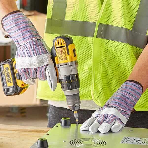 A person using a Cordova canvas work glove to drill holes in metal.