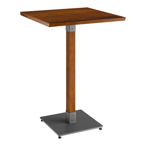 A Lancaster Table & Seating bar height table with a wooden top and metal base.