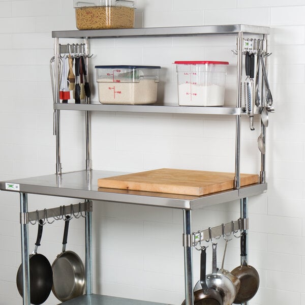 A Regency stainless steel overshelf with utensils and a cutting board.
