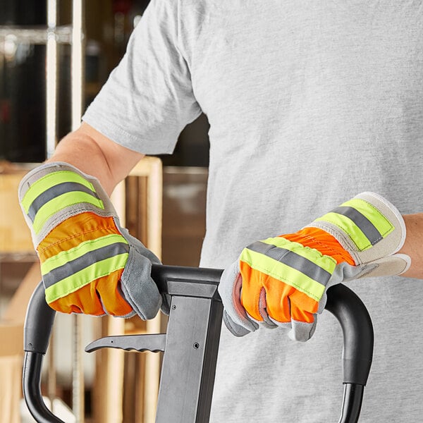 A person wearing Cordova Hi-Vis work gloves while driving a forklift.