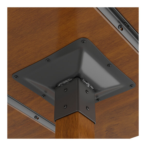 A Lancaster Table & Seating wood table with metal corner brackets.