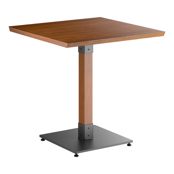 A square wooden table with a rustic walnut finish, supported by a single central wooden leg and a black metal square base.