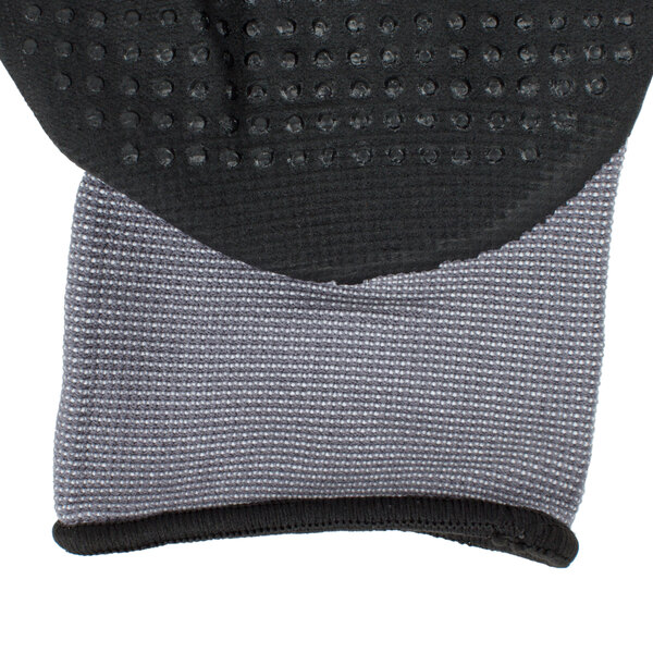 A close up of a grey Cordova Conquest Max glove with black and nitrile dots.