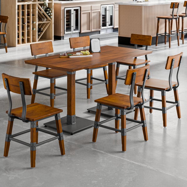 A Lancaster Table & Seating rustic walnut wood table with chairs in a room.