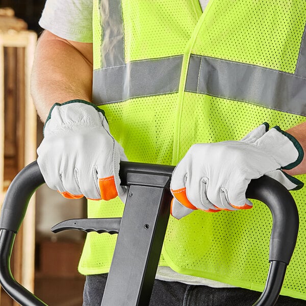 A man wearing Cordova warehouse gloves with hi-vis fingertips holding a tool.