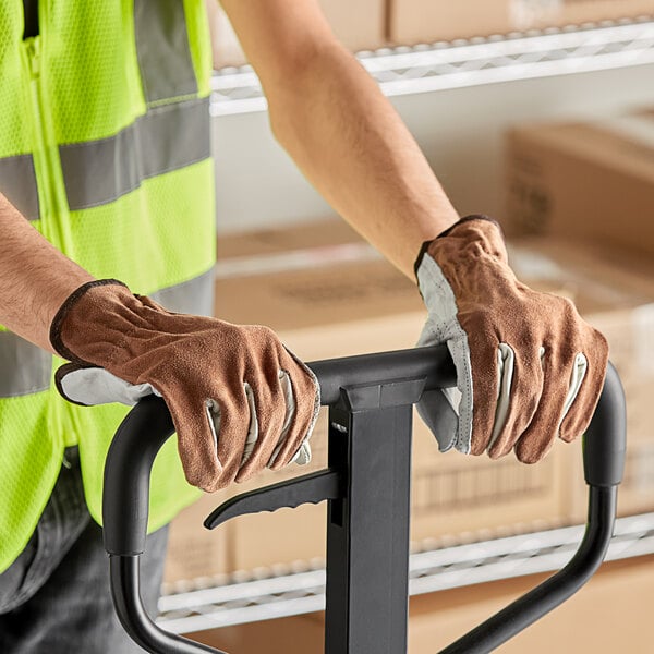 A person wearing Cordova Select Grain Cowhide Leather Driver's Gloves holding a hand truck.