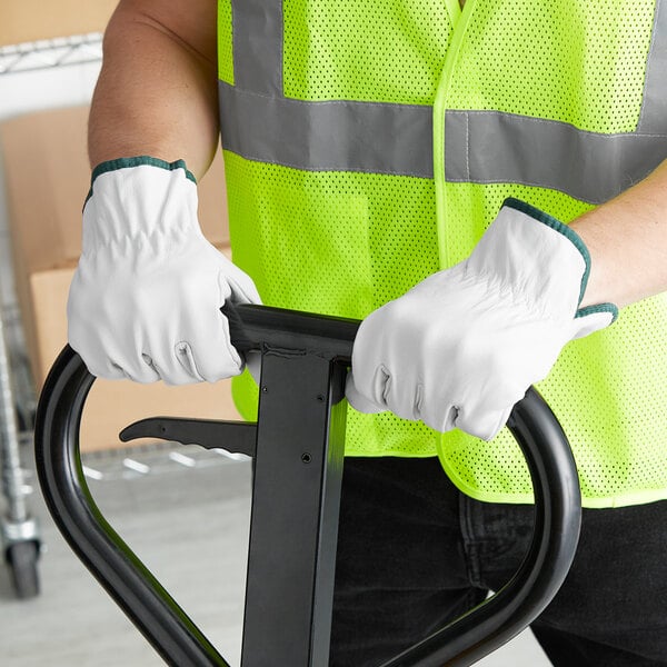 A person wearing Cordova gray leather driver's gloves holding a hand truck.