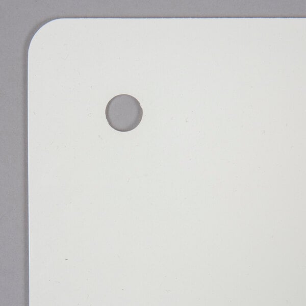 A white rectangular San Jamar cutting board mat with a hole in the corner.