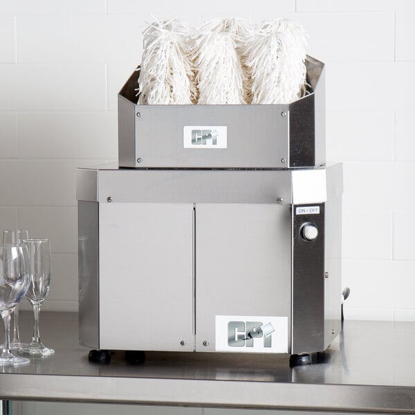 A silver Campus Products GP8 Stemshine electric glass polisher machine with white paper in it.