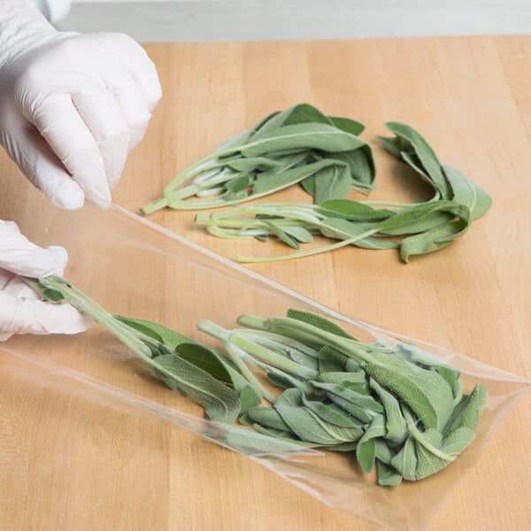 A person in gloves holding a LK Packaging plastic food bag of sage leaves.
