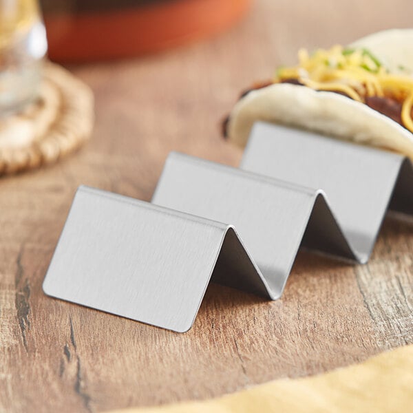 A stainless steel mini taco holder with a taco in it.