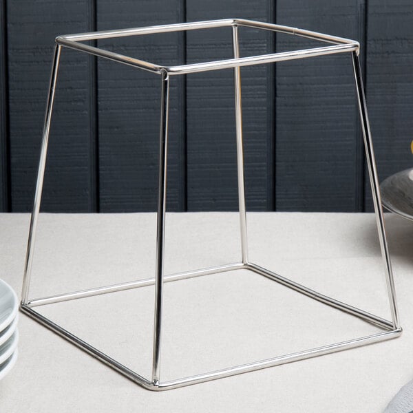 An Acopa stainless steel display stand with a plate on it.