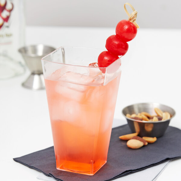 A clear plastic Fineline Wavetrends tumbler with a pink drink, ice, and a cherry on top.