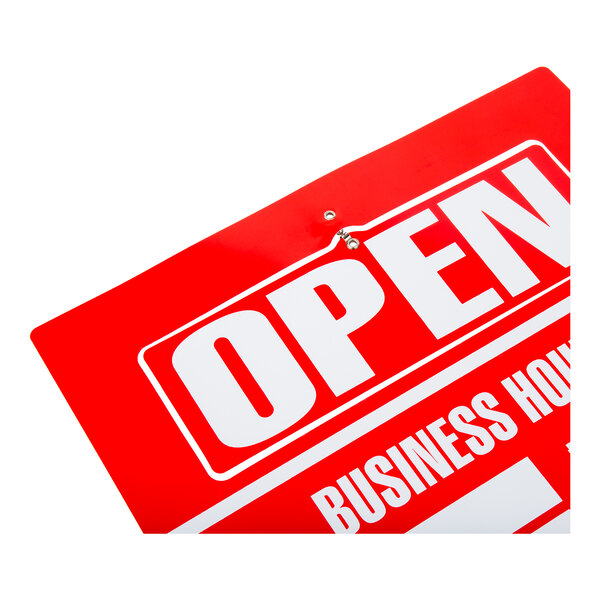 A partial view of a red and white sign displaying the word 'OPEN' and part of the phrase 'BUSINESS HOURS.'