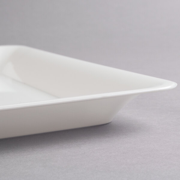 A close-up of a Fineline white plastic square catering tray with a lid on it.
