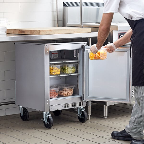 A man in a kitchen with a Beverage-Air undercounter refrigerator.