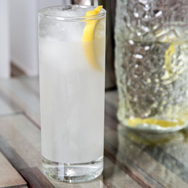 A close-up of a Libbey frosted clear lip zombie glass filled with water and a lemon slice.