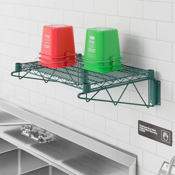 A green and red bucket on a Regency green epoxy wire wall mount shelf.